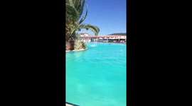 Shocking footage shows the moment a mini-tornado tore around the swimming pool of a posh hotel and sent parasols flying