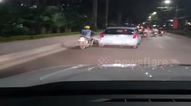 The man used his legs to push the damaged car on the road