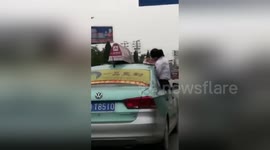 Schoolgirl hangs out of window to finish homework on roof of taxi
