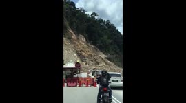 Watch huge boulders tumble down mountainside as landslide blocks road