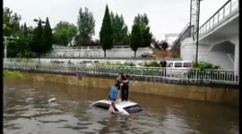 Woman rescued from car trapped in flooded street