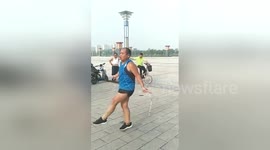 Man performs skipping rope moves in city square