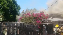 Fireman on the roof looking like Dday with billows of smoke around them taking axes to theroof so that they can get hoses in to the source of fire, Fire occurred 5/17/2018 near corner of 18th ave and Pima in Phoenix AZ behind Church