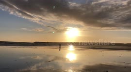Walking on the sandy beach by the ocean