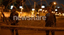 Women stand near a barbed wire blockade by Egypt's Presidential Palace