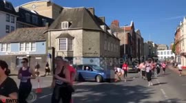 Hilarious moment a frustrated woman drives into a half marathon and is stopped by runners
