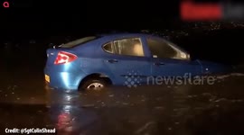 Shocking footage shows a car being washed out to sea.