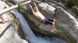 Guy swinging over waterfall falls on rocks