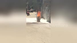 Villagers desperately try and fail to extinguish moped fire