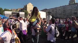 Fans of Real Madrid take on the head of the girl - fan coordinator and sing singing in the fan zone next to the