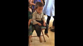 The boy fell asleep while sitting on a chair so cute