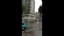 Couple bailing out rain from balcony downpour