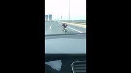 The man lying on the motorbike moving at high speed on the highway