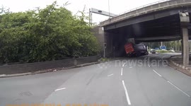 Dashcam captures moment when truck overturns as it passes underneath bridge