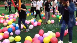 High school senior students step on thousands of balloons to release pressure