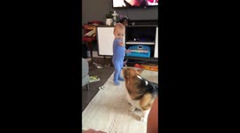 Twin baby feeds dog while trying to say dog’s name