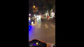 The man riding a motorbike with a wheel on the busy road