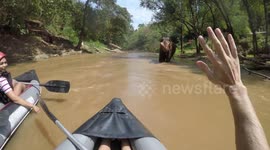 Elephant calmly continues shower as rafters drift past