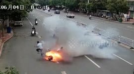 Two men leap off moving scooter after it bursts into flames on busy road