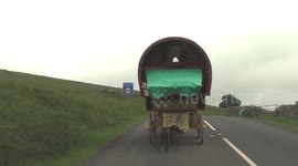 Traditional gypsy caravans making their way to the Appleby Horse Fair with dog in tow
