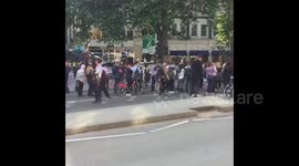 Crowds gather at cordoned-off area near luxury hotel