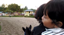 two kids try to rid a horse