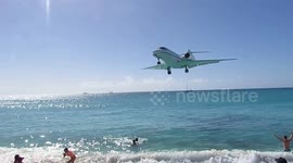 Aircraft flies over tourists' heads at Caribbean beach before airport landing
