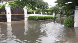 Kids playing in flooded backstreet in Bangkok.