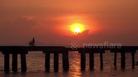 Video captures silhouette of cyclist against beautiful sunset