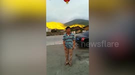 Chinese tourists pose in front of 'golden mountain'