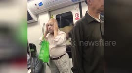 Chinese man applies face mask while on busy train