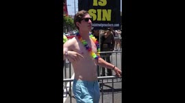 LA Gay Pride parade goer dances and poses in front of anti-gay protestors