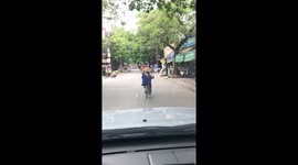The woman cycling with a ladder on the neck
