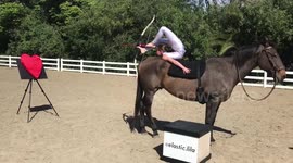 Kid contortionist performs foot archery on horseback