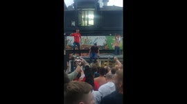 Excited England fans climb atop bus stop in celebration of win against Tunisia