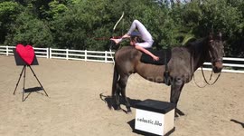 Kid contortionist performs foot archery on horseback