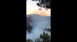 Firefighting helicopters drop water on fire in Griffith park