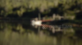 Reflection of boat, pier and african bush on an african river. Very dreamy and peaceful