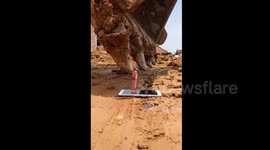 Delicate touch: Chinese labourer uses excavator to light a lighter