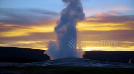 Yellowstone's Old Faithful geyser eruption captured at sunset