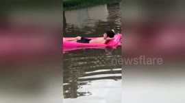 Boy lounges on pool float in the middle of severe Texas flood