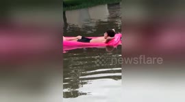 Boy lounges on pool float in the middle of severe Texas flood
