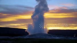 Yellowstone's Old Faithful geyser eruption captured at sunset