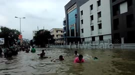 People wade through floodwater in Gujarat, India