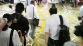 People wade through a flooded subway station in Japan
