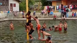 Bizarre pole-climbing ritual sees Indonesian men test agility and strength for prizes