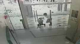 Angry Chinese woman with baby shoves glass door, making it shatter