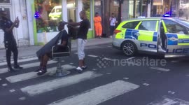 Bizarre moment man gets haircut done in the middle of London road