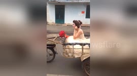 Just hitched: Groom carries bride along road in motorbike rickshaw