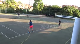 Tennis pairs enjoy a game in Holland Park on summer evening